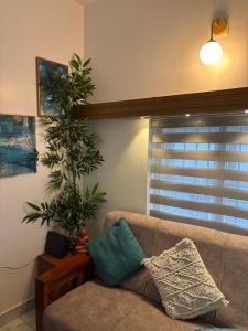 a living room with a couch and a plant at Nitara Beach House in Kannur