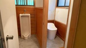 a small bathroom with a toilet and a urinal at 1日1組様限定 最大10名様 キャンプ 温泉付き Villa 水と深緑 in Azumino +39 photos