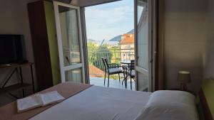 a bedroom with a bed and a view of a balcony at Luna di mare 2 Igalo in Igalo