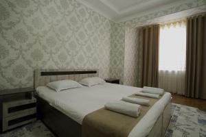 a bedroom with a bed with towels on it at Hotel Ayyub Sultan in Urganch