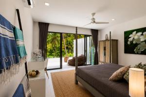 a bedroom with a bed and a large window at INDIGO VILLA Samui in Koh Samui