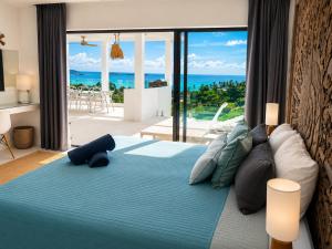 a bedroom with a bed with a view of the ocean at INDIGO VILLA Samui in Koh Samui