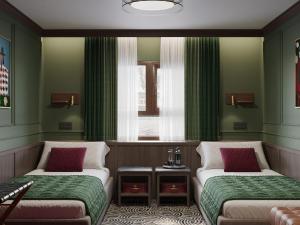two beds in a room with green walls and a window at Botel Albatros in Prague