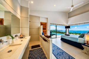 a bedroom with a bed and a view of the ocean at INDIGO VILLA Samui in Koh Samui