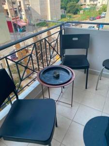 a balcony with two chairs and a table and a window at Calypso Rooms in Preveza