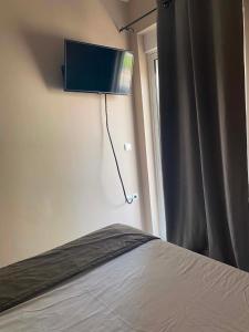 a bedroom with a bed and a television on the wall at Calypso Rooms in Preveza