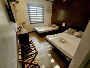 a room with two beds and a window at Cleon Villas Pension in Puerto Princesa City
