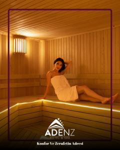 a woman is sitting in a sauna at Adenz Otel in Elmadağ