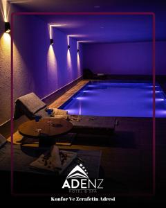 a swimming pool in a room with purple lighting at Adenz Otel in Elmadağ