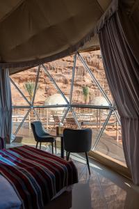 a room with a bed and chairs and a window at Valley Resort in Wadi Rum