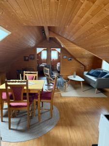 a living room with a wooden ceiling and a table and chairs at Lysbøen Bua in Ramberg