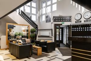 a living room with a couch and a piano at Hotel Aateli Lakeside in Vuokatti