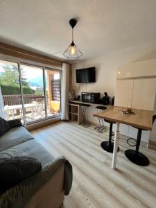a living room with a couch and a table at Chaleureux appartement moderne in Briançon
