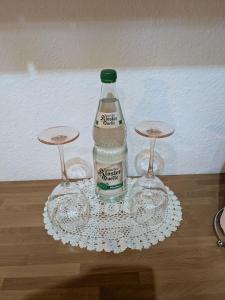 a bottle and two wine glasses on a table at FeWo am Heimlisberg in Friesenheim