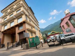 ein Gebäude, vor dem ein Auto geparkt ist in der Unterkunft The Ginger McLeodGanj-By Vaikunth Centrally Heated & Air Cooled # Near Mall Road # Big Parking # Lift #Spacious Rooms # Most Awarded # Property Of The Year # in McLeod Ganj