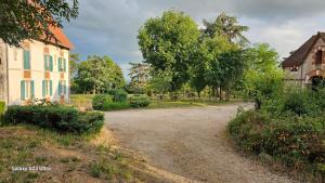 a dirt road next to a house and trees at Chambre Henri II in Fleuriel