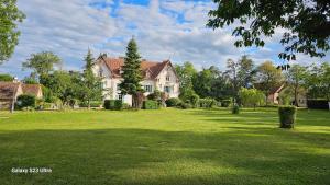 a large house in a field of green grass at Chambre Henri II in Fleuriel