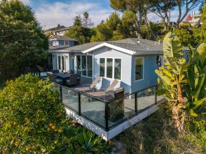 a house with a wrap around deck with a glass balcony at Summerland SeaSpa Retreat | The Chosen Collection in Summerland