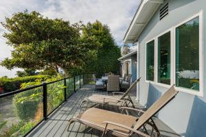 a deck with chairs and tables on a house at Summerland SeaSpa Retreat | The Chosen Collection in Summerland +48 photos