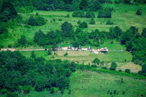 a group of houses on a hill in a field at Sunčani Brijeg Eco Village in Plav