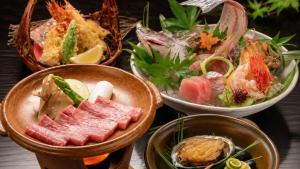 a group of bowls filled with different types of food at Tabist Yuasa Castle Onsen Hotel in Yuasa