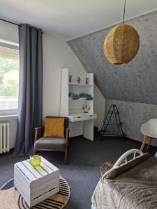 a bedroom with a bed and a chair and a table at Ruhige Ferienwohnung an der Vechte - Zweites Glûck in Nordhorn