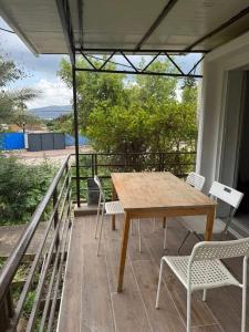 a wooden table and chairs on a porch with a view at Hamsa Apartment in Menaẖemya