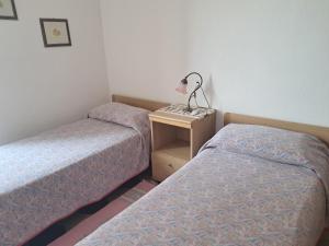 a room with two beds and a table with a lamp at Casa MAX in Onno