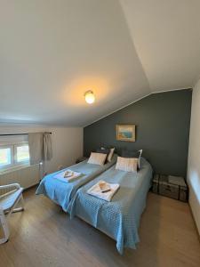 a bedroom with two beds and a green wall at Korpinpesä in Korppoo