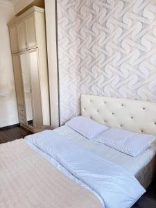 a bedroom with a white bed with a wall at Grand BIGHOUSE in Dilijan +150 photos