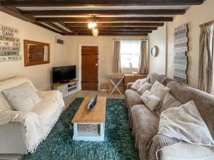 a living room with a couch and a coffee table at Bacchus Cottage - Uk51964 in Sutton on Sea