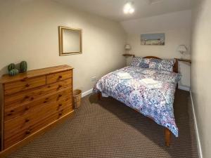 a bedroom with a bed and a wooden dresser at Bacchus Cottage - Uk51964 in Sutton on Sea +5 photos