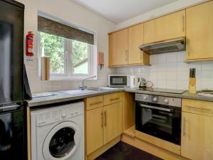 a kitchen with a washer and a dishwasher at Thistle Cottage in Ryde