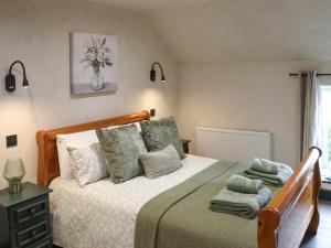 a bedroom with a large bed with green pillows at Brynawel in Maenclochog