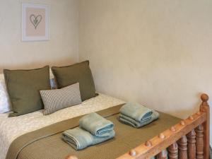 a bedroom with a bed with two pillows on it at Brynawel in Maenclochog