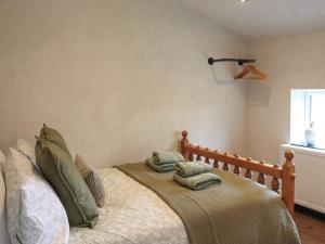 a bedroom with a bed with green pillows on it at Brynawel in Maenclochog +5 photos
