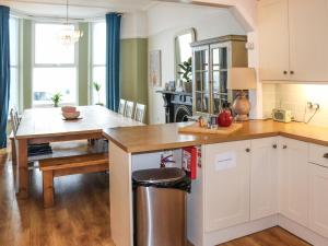 a kitchen with a table and a dining room at Bay View - Uk52077 in Criccieth