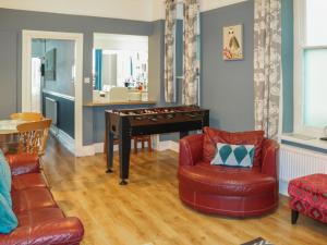 a living room with a piano and a chair at Bay View - Uk52077 in Criccieth
