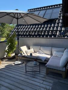 a couch and an umbrella on a patio at Ferienwohnung Lang in Nümbrecht