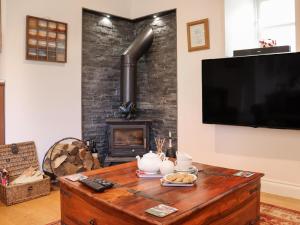 a living room with a tv and a fireplace at The Quarry Stables in Cheddar