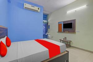 a bedroom with a bed and a tv in it at Hotel O Satya Inn in Karīmnagar