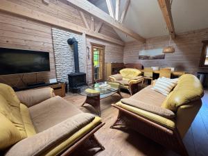 a living room with two couches and a fireplace at Klimatyczny domek z drewna nad morzem in Debina