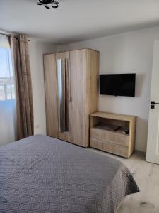 a bedroom with a bed and a cabinet and a television at Casa Joe in Corbu