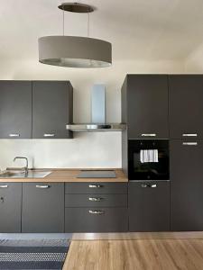 a kitchen with gray cabinets and a sink at Appartamenti Monti Como Lake in Brunate