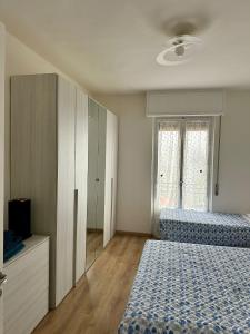 a bedroom with two beds and a large window at Appartamenti Monti Como Lake in Brunate