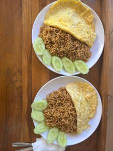 two plates of food with noodles and a burrito at VIA Homestay 1 in Kuta Lombok