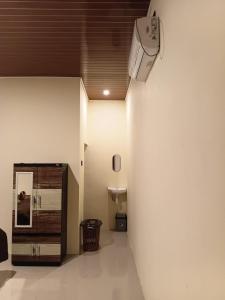 a room with a ceiling fan and a wall at VIA Homestay 1 in Kuta Lombok