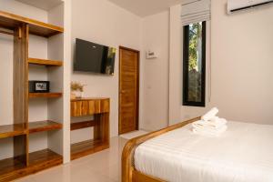 a bedroom with a bed and a tv on a wall at Blue Sky Seaview in Haad Yao