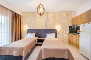 a hotel room with two beds and a kitchen at Μυρτιές-Mirties in Siviri