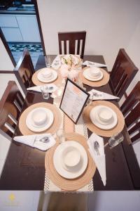 a dining table with plates and straw hats on it at Sam's Residence in Marilao